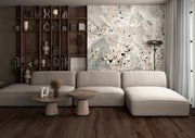 Modern living room with a gray sectional sofa, wooden shelves, and abstract wall art.